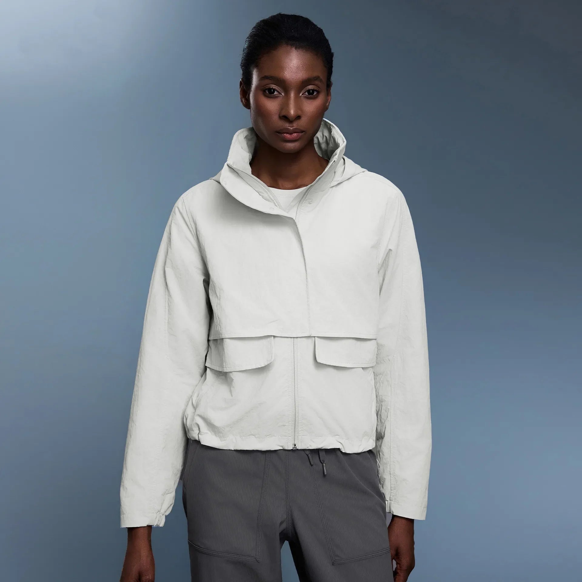 Veste coupe-vent d'extérieur pour femme avec capuche rétractable.