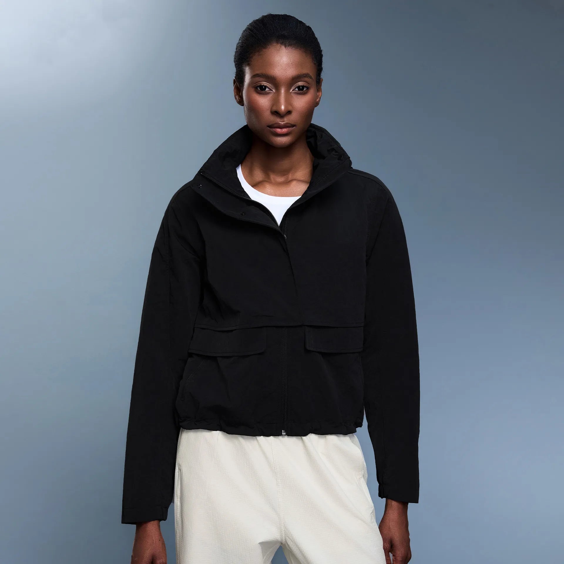 Veste coupe-vent d'extérieur pour femme avec capuche rétractable.