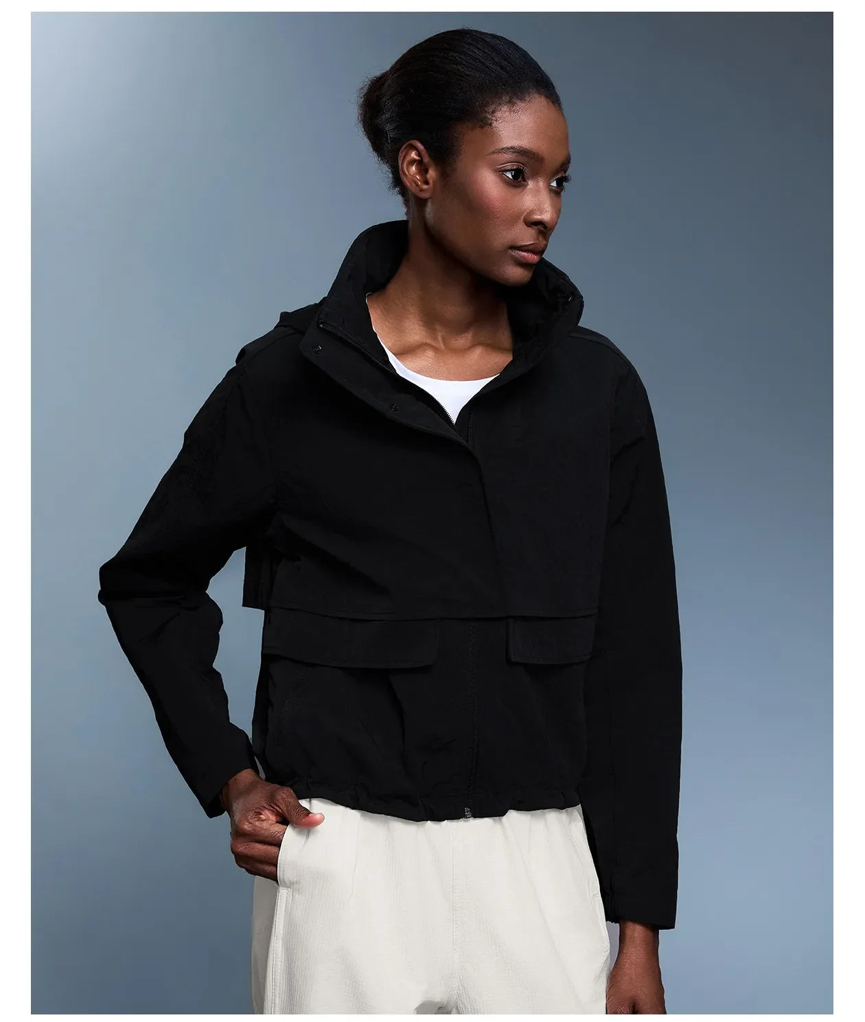 Veste coupe-vent d'extérieur pour femme avec capuche rétractable.