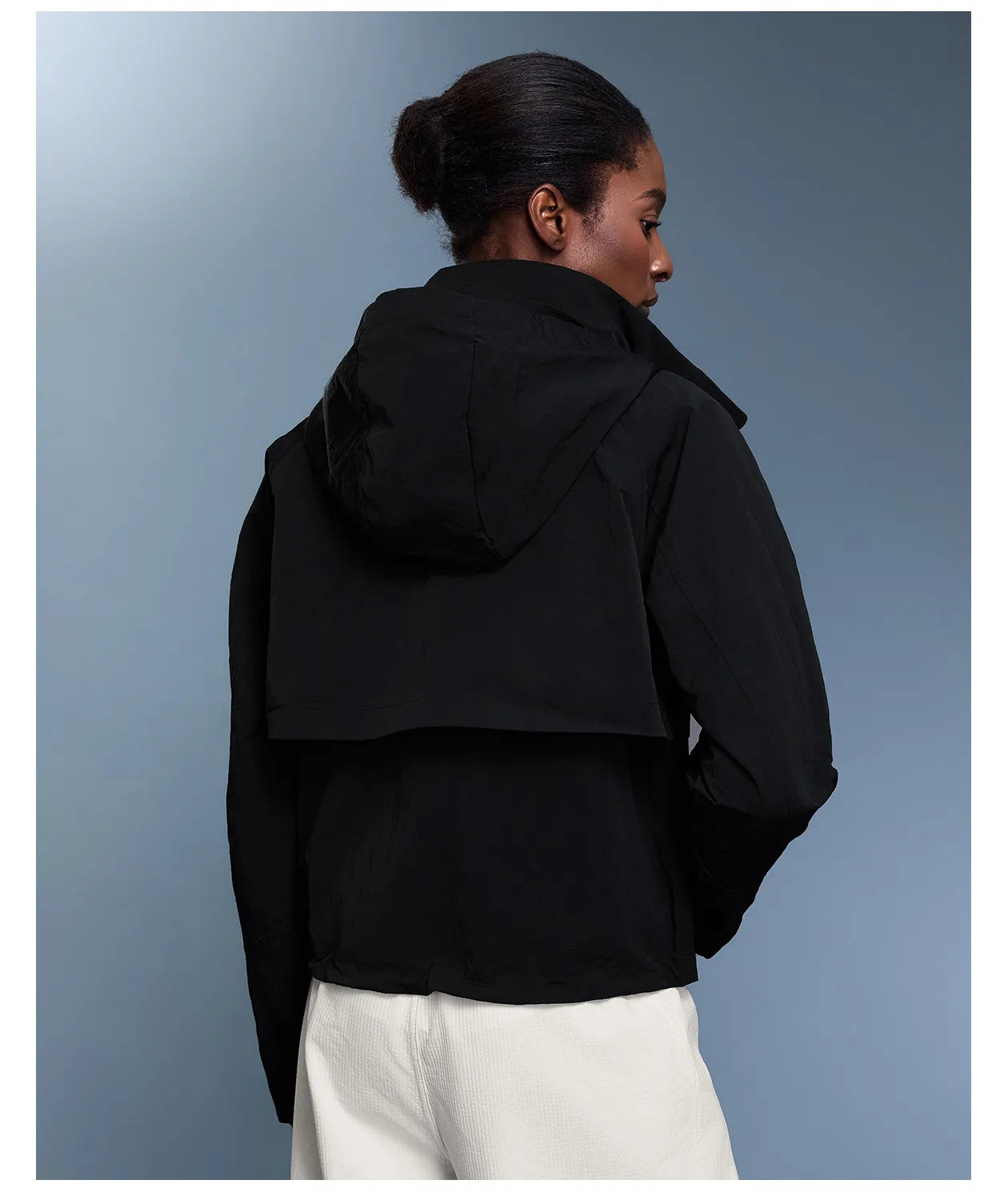 Veste coupe-vent d'extérieur pour femme avec capuche rétractable.