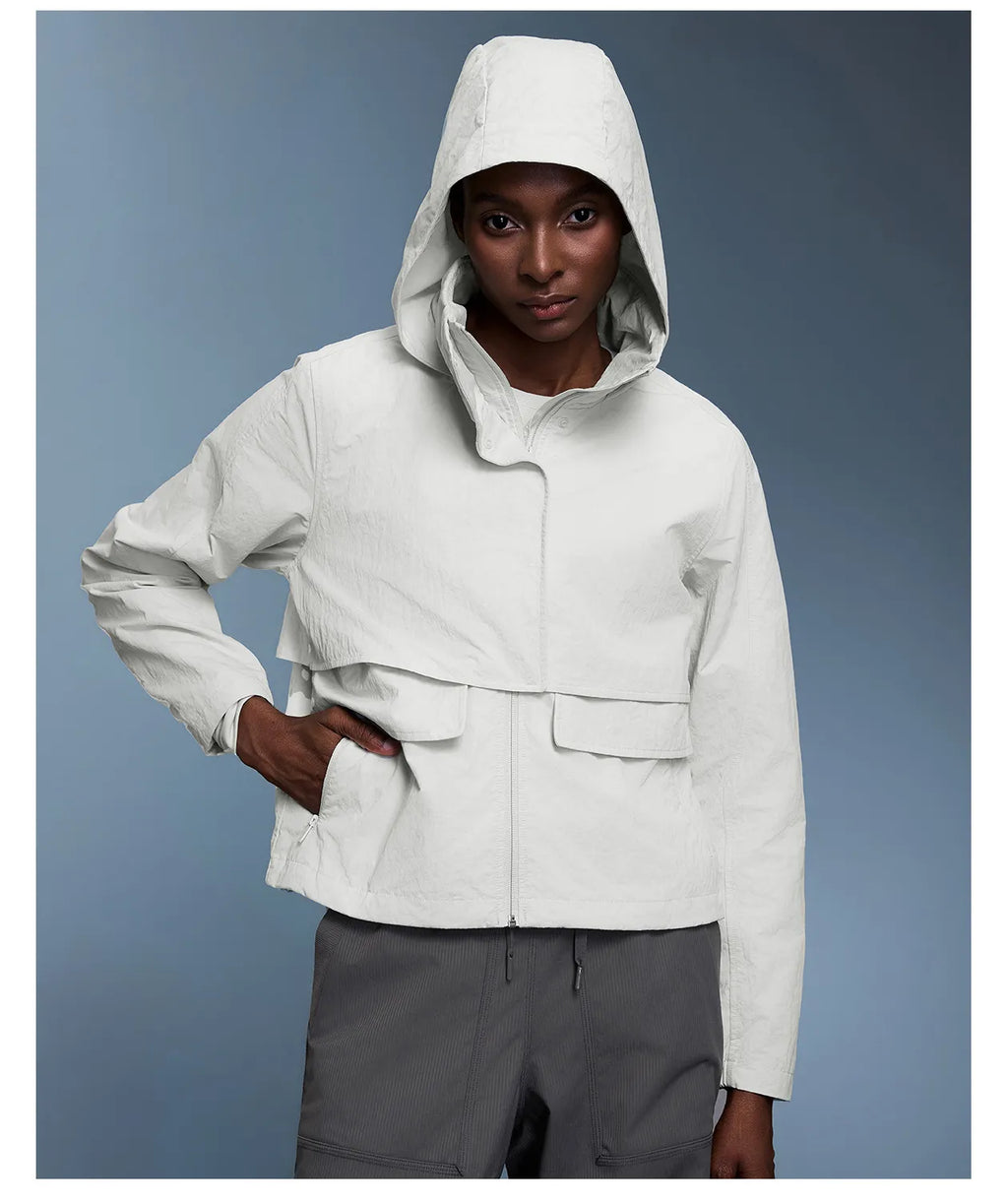 Veste coupe-vent d'extérieur pour femme avec capuche rétractable.