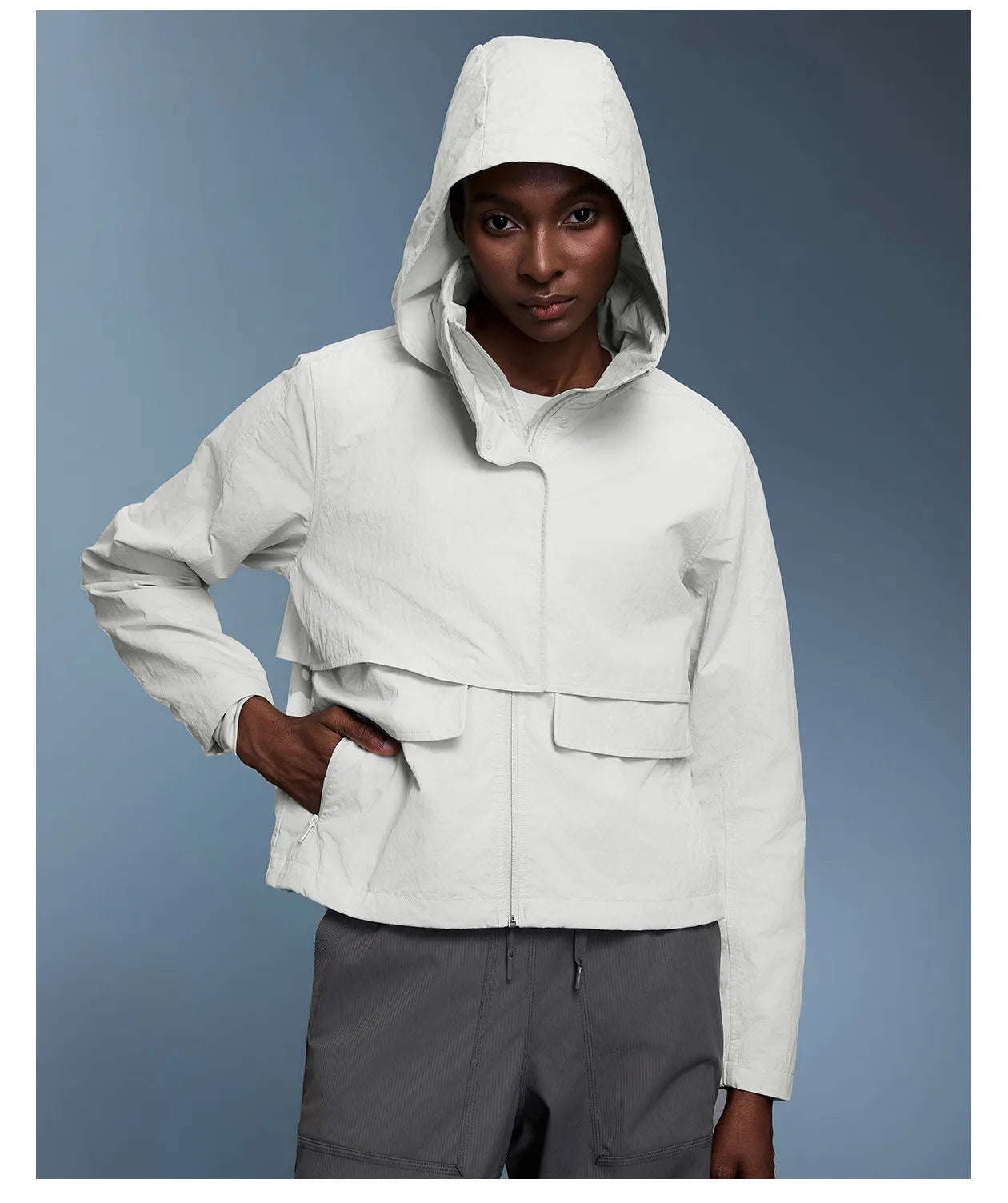 Veste coupe-vent d'extérieur pour femme avec capuche rétractable.