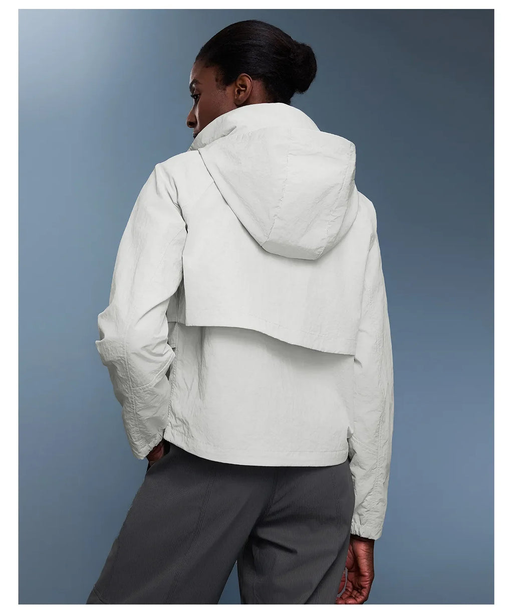 Veste coupe-vent d'extérieur pour femme avec capuche rétractable.