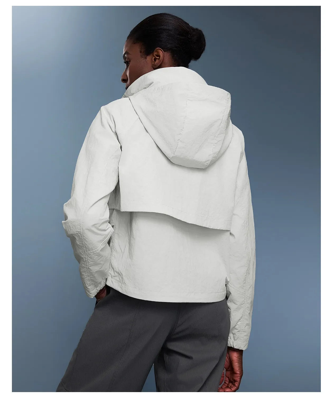 Veste coupe-vent d'extérieur pour femme avec capuche rétractable.